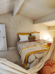 1 dormitorio con 1 cama con pájaros en la pared en Ahoma, séjour bien-être, calme et sérénité., en Labruguière