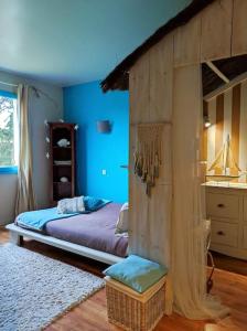 1 dormitorio con 1 cama en una habitación azul en Ahoma, séjour bien-être, calme et sérénité., en Labruguière
