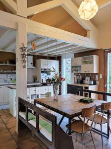cocina grande con mesa de madera y sillas en Ahoma, séjour bien-être, calme et sérénité., en Labruguière