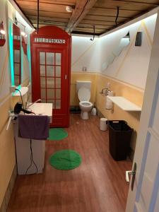 La salle de bains est pourvue d'une cabine de téléphone rouge et de toilettes. dans l'établissement Hotel Schönbrunnen, à Münchenbuchsee