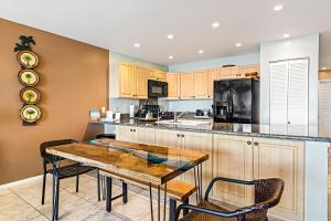 a kitchen with a table and chairs and a microwave at Sea Village 1105 in Kailua-Kona