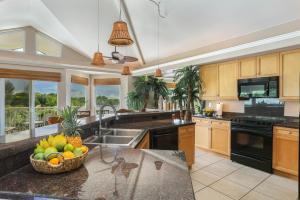 a kitchen with a bowl of fruit on the counter at Nohea Villa in Princeville