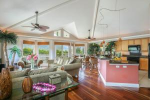 a living room with couches and a kitchen at Nohea Villa in Princeville