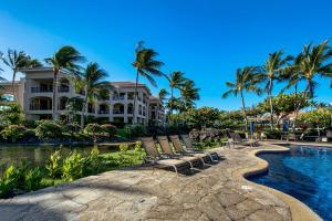 um resort com piscina, cadeiras e palmeiras em Shores At Waikoloa Beach Resort 332 em Waikoloa