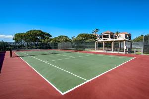 a tennis court with a house in the background at Shores At Waikoloa Beach Resort 332 in Waikoloa