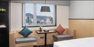 a bedroom with a bed and a table with pillows at Xin'an Yihao Hotel - Near Xiamen Railway Station, near Vientiane City, minibar is free in Xiamen