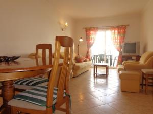 a living room with a table and chairs and a couch at Apartamento Avenida da Liberdade in Albufeira