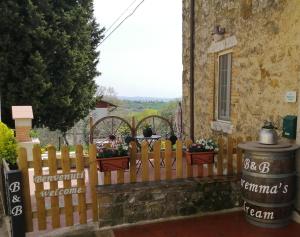 a wooden fence in front of a house with flowers at B&B Maremma's dream in Catabbio