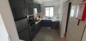 a kitchen with black cabinets and a sink at P209 Balaia Golf Village in Albufeira