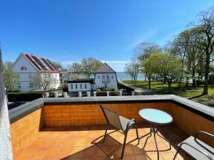a patio with a table and a chair on a balcony at Villa am Meer - Stralsund in Stralsund