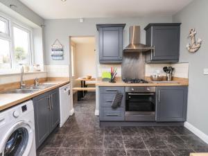 a kitchen with a sink and a stove top oven at The Beach Huts in Hornsea