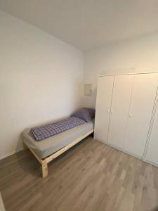 een kleine slaapkamer met een bed en witte kasten bij Salí - 2BR - Mid Apartment in Kleve