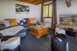 a living room with a couch and a tv at Chalet Aravista - OVO Network in Le Grand-Bornand