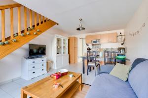 a living room with a blue couch and a table at À deux pas de la plage, jolie maison pour 4 in Notre-Dame-de-Monts