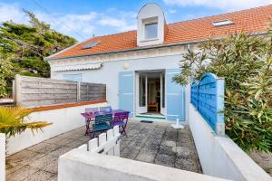 a house with a purple table and chairs on a patio at À deux pas de la plage, jolie maison pour 4 in Notre-Dame-de-Monts