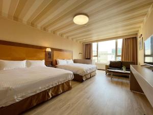 Habitación de hotel con 2 camas y ventana en Gueylin Hotel en Luzhu