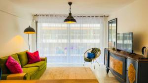 uma sala de estar com um sofá verde e uma grande janela em Elegant, Spacious, Central em Nice