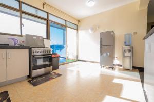內羅畢的住宿－Art-inspired 3BR Apartment，厨房配有炉灶和冰箱。