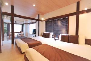 a bedroom with two beds and a large window at TOGOSHI 568 STAY Togoshi Ginza in Tokyo