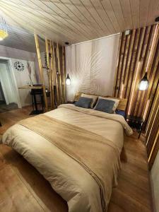 L'AbergementL’Écho des Bois - Studio cocooning avec sauna的一间卧室配有一张大床和两个蓝色枕头
