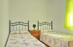twee bedden naast elkaar in een slaapkamer bij Chalet Aroca in Conil de la Frontera