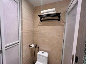 a bathroom with a toilet and a towel rack at Reka Hotel Genting Highlands in Genting Highlands