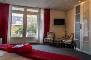 een kamer met een bed met een rood kussen erop bij Hotel Kijkduin in Domburg