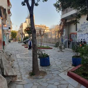 een straat met een boom en een stenen stoep bij Success's Apartment in Athene