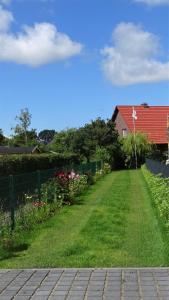 einen Hof mit einem Haus und einem roten Dach in der Unterkunft Ferienhaus im urigen Garten bzw Eulenhaus in Zingst