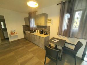 a kitchen with a table and a dining room at BELLA DE LUX RESIDENCE in Kato Korakiana