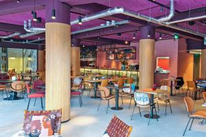 ein Restaurant mit Tischen, Stühlen und lila Decken in der Unterkunft Stayokay Hostel Utrecht Centrum in Utrecht