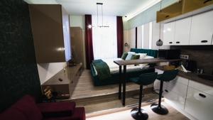 uma cozinha com uma mesa e uma cama num quarto em Dream Apartments em Szeged