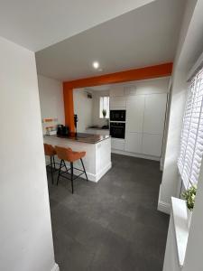 a kitchen with white cabinets and a table and chairs at Unique New 4 Bedroom House, HS2, Business People, Contractors & Families in Minworth