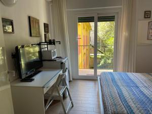 a bedroom with a desk with a television and a bed at La Ricciola - Eurotel 523 in Rapallo