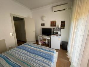 a bedroom with a bed and a desk with a microwave at La Ricciola - Eurotel 523 in Rapallo