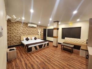 a bedroom with a bed and a couch in it at Hotel WB40 in Durgāpur