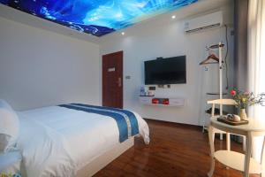 a bedroom with a bed with a blue ceiling at Yijingju Humanistic Inn in Zhangjiajie