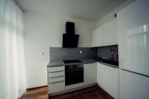 a kitchen with white cabinets and a stove top oven at TIFFANY Apartment Hotel in Bratislava +55 photos