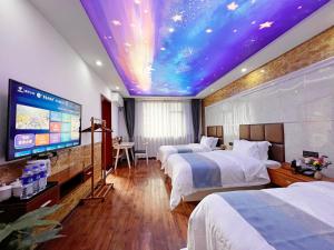 張家界市にあるYijingju Humanistic Innのベッド2台と天井が特徴のホテルルームです。