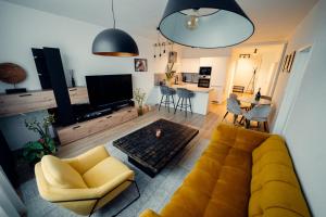 a living room with a yellow couch and a kitchen at TIFFANY Apartment Hotel in Bratislava