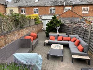 a patio with a couch and chairs and a table at Bluebell Cottage , 36 Main Street in Alveston
