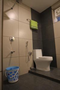 a bathroom with a toilet and a shower and a bucket at Agronest Farm & Resort By Teal Luxury Stay in Wayanad