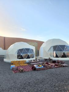 duas cúpulas com comida no chão em frente a um edifício em Bidiyah Domes em Badīyah