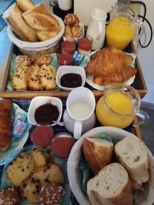 - un plateau de nourriture avec du pain et d'autres aliments pour le petit-déjeuner dans l'établissement O Douceurs Sucrées Cabourg, à Cabourg