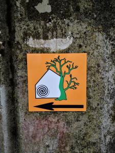 un cartel en una pared con un árbol. en Mountain lodge Forte Emilia, en Kobarid