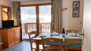 泰爾米尼翁的住宿－Au coeur du Parc National de la Vanoise Appart Termignon Val Cenis，一间带桌椅和窗户的用餐室