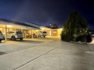 a building with cars parked in a parking lot at night at Kinross Inn in Cooma
