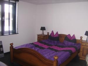 a bedroom with a bed with purple sheets at Ottenskamp4 in Siebengewald