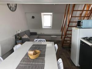 sala de estar con mesa blanca y cocina en Le Bachelin, en Saint-Omer