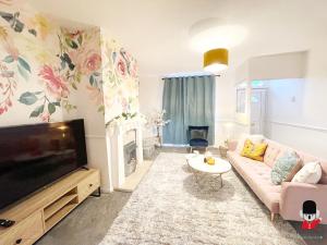 un salon avec un canapé et une télévision à écran plat dans l'établissement KozyGuru / 2 BR 4Bed / Blossom Garden / Next to Big Retail Park and Train station / Worsley Manchester / 16 mins to City Centre / UMWO187, à Worsley